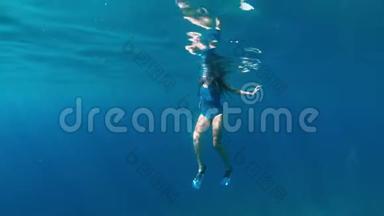 时尚和运动的女孩独自在海洋深处潜水。 浅棕色的浅黑色在蓝色海洋深处潜水